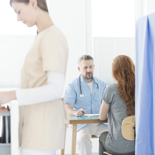 Gynecologist talking to a woman during consultation in the office with a nurse